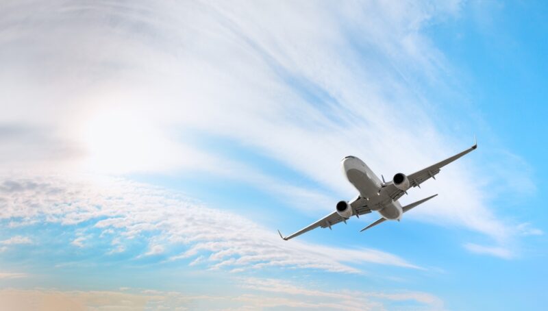 空を飛ぶ白い旅客機